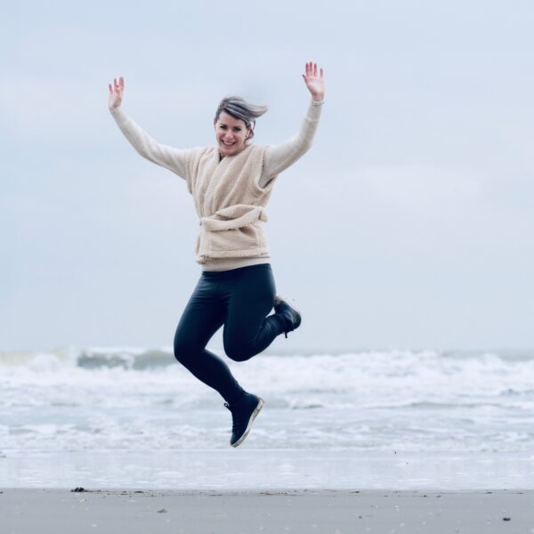 Vrouw springt in het bos, tips om uit je comfortzone te komen