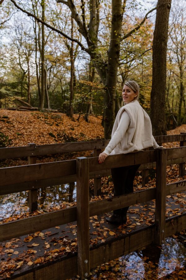 Vrouw in een herfstbos met het gevoel dat ze te veel moet
