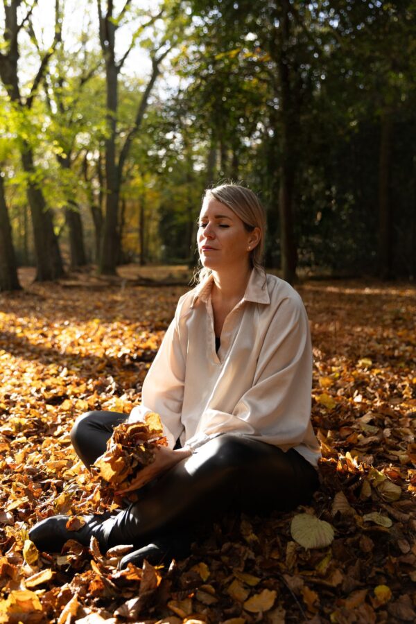 Vrouw tussen herfstbladeren die ontdekt dat ze te veel pleast